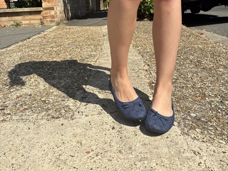 Worn in navy flats on the footpath